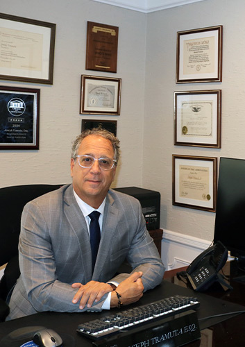 Photo of Joseph Tramuta sitting at office desk
